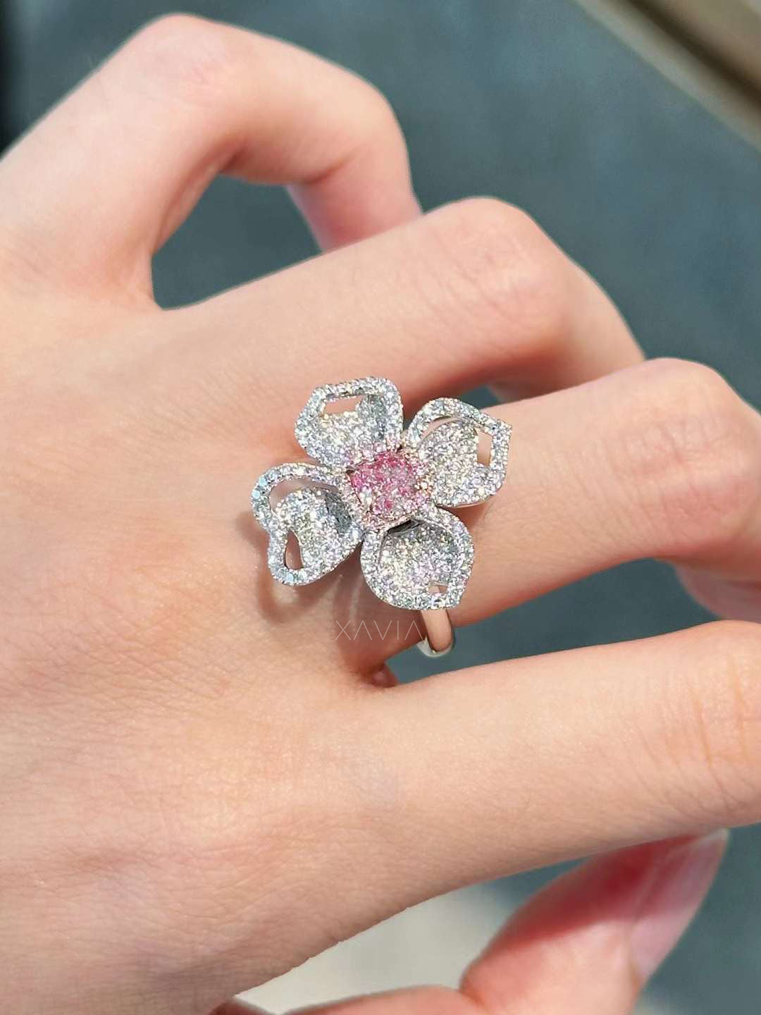 detailed hand shot of Petralisse pink diamond floral ring, pavé-set petals sparkling in white gold setting